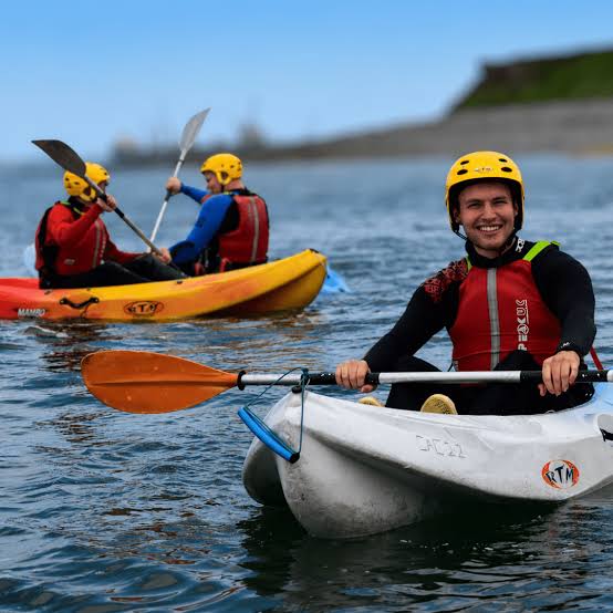 Kayakers in helmets and buoyancy aids paddling on the lough.