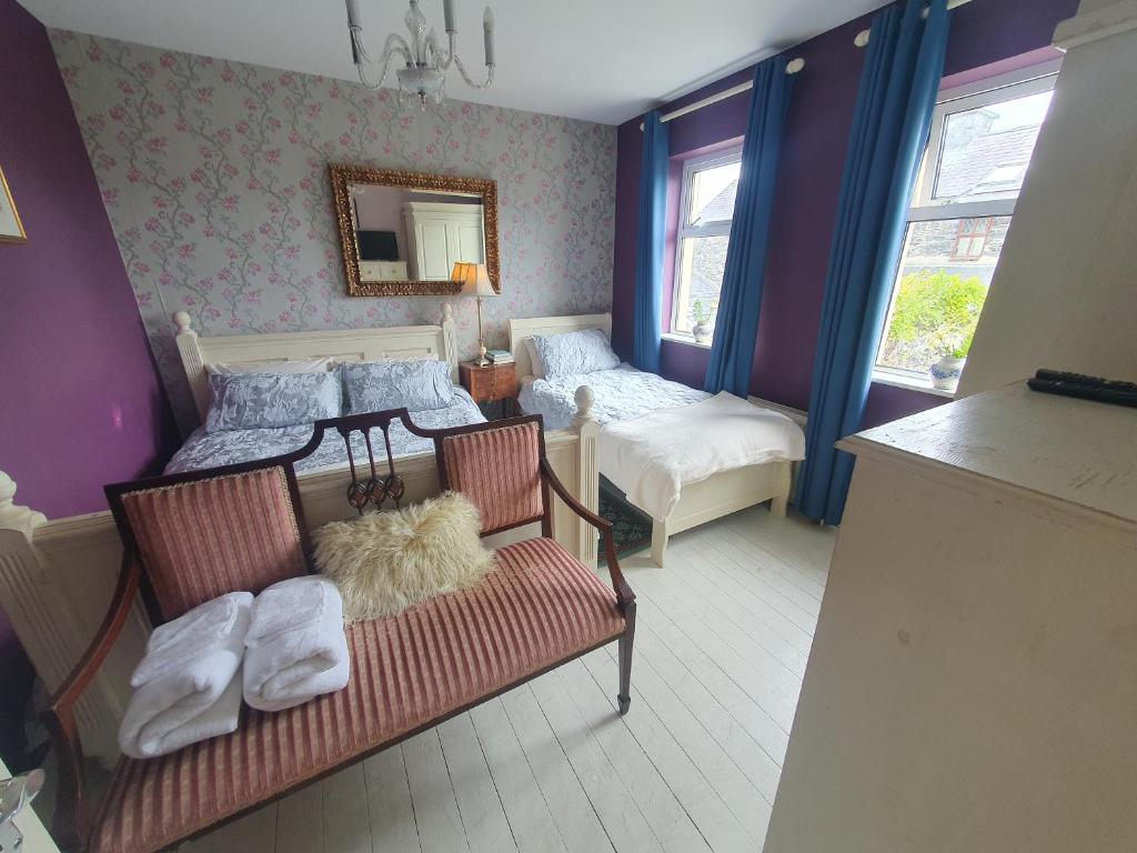 Bedroom two at the back of the house: a bed and a single bed with blue
                    curtains, a gilt mirror and a chaise at the foot of the bed.