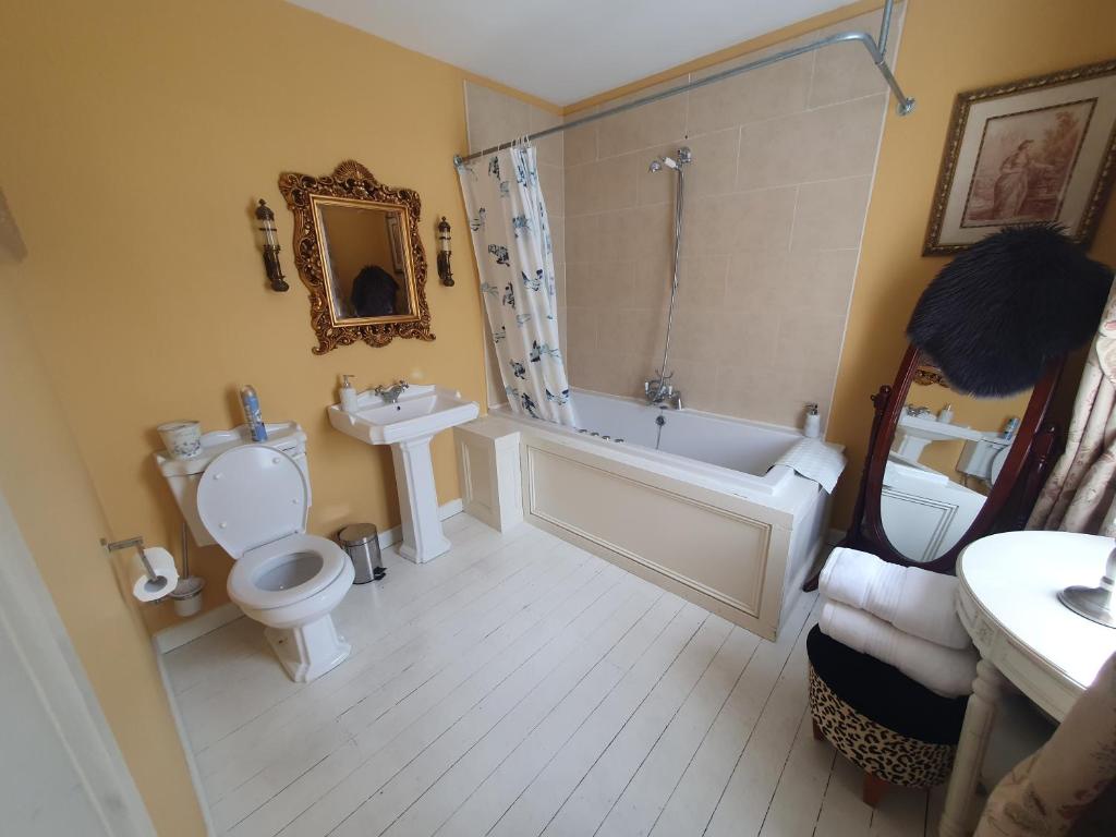 The second bathroom: bath with a shower over it, pedestal basin, WC and a
                      gilt mirror.