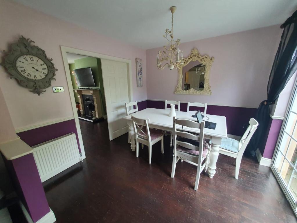 The dining room off the kitchen: a white table seating six under a chandelier,
                  with the living room through the door and the patio to the side.