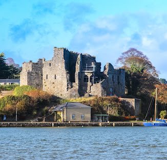 King John&rsquo;s Castle, Carlingford: the ruined Norman keep on its rock
                    above the lough, seen from the water on a bright day.